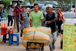 A man pushes a load as he works as a “lomo taxista,” or taxi of the lower back, outside a bus terminal in San Antonio, Venezuela, Sept. 19, 2019.