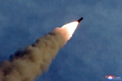 FILE - A missile is fired during the test of a multiple rocket launcher in this undated photo released Aug. 25, 2019, by North Korea's Korean Central News Agency.