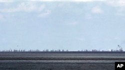 FILE - The alleged on-going reclamation of Subi Reef by China is seen from Pag-asa Island in the Spratly Islands in the South China Sea, western Palawan Province, Philippines, May 11, 2015.