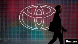 Seorang pria berjalan melewati logo Toyota di Tokyo Motor Show, di Tokyo, Jepang, 24 Oktober 2019. (Foto: REUTERS/Edgar Su)