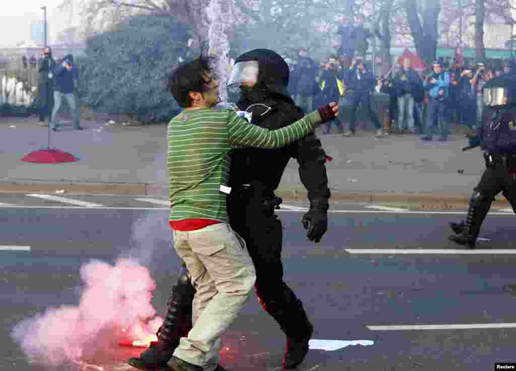 Seorang polisi memberhentikan demonstran anti-kapitalis &#39;Blockupy&#39; dekat gedung Bank Sentral Eropa (ECB) sebelum pembukaan resmi markas besar barunya di Frankfurt 18 Maret 2015. (REUTERS/Michael Dalder)