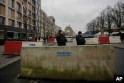 Naoružani policajci stoje ispred betonskih blokova raspoređenih oko Brandenburške kapije u Berlinu