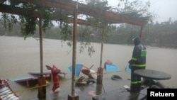 Seorang pria tampak mengamati banjir yang diakibatkan oleh badai tropis Kompasu di Baguio, Filipina, pada 12 Oktober 2021. (Foto: Baguio Tourist Police/Handout via Reuters)