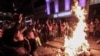 People gather around a bonfire before riot police use a water cannon to disperse protesters during a rally against a bill which would allow Turkey's authorities to block web pages for privacy violations without a prior court decision, in Istanbul, Feb. 22, 2014.