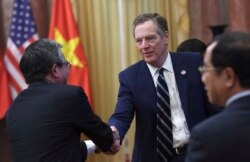 FILE - U.S. Trade Representative Robert Lighthizer shakes hands with Vietnamese Ambassador to the U.S. Pham Quang Vinh as they wait for the welcoming ceremony of U.S. President Donald Trump at the presidential palace in Hanoi, Nov. 12, 2017.