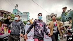 Para warga yang melakukan aksi protes terhadap pemerintah berjalan di area Mandalay, Myanmar, dalam aksi yang berlangsung pada 7 Desember 2021. (Foto: AP)