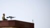 FILE - A sniper keeps a watch from the roof of the parliament building before Afghan President Ashraf Ghani arrives at the parliament in Kabul, Afghanistan, August 2, 2021.