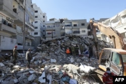 Recuers sift through the rubble of a collapsed building in the regime-controlled town of Jableh in the province of Latakia, northwest of the capital Damascus, on Feb. 9, 2023, days after a deadly earthquake hit Turkey and Syria.