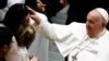 Pope Francis is greeted by people during the weekly general audience at the Vatican, Jan. 25, 2023. 