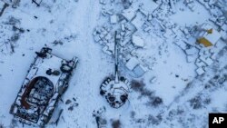 A destroyed Russian tank, covered in snow, stands in the yard of a private house in the town of Sviatohirsk, Ukraine, Feb. 12, 2023. 
