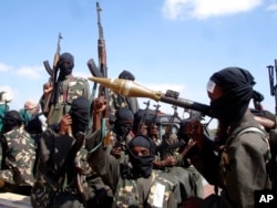 FILE - Armed al-Shabab fighters ride on pickup trucks as they prepare to travel into the city, just outside the capital Mogadishu, in Somalia on Dec. 8, 2008.
