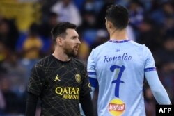 Penyerang Paris Saint-Germain Argentina Lionel Messi (kiri) berjalan melewati penyerang Portugal All-Star Riyadh Cristiano Ronaldo (kanan) selama pertandingan sepak bola Piala Musim Riyadh antara Riyadh All-Stars dan Paris Saint-Germain di Stadion King Fahd di Riyadh pada 19 Januari 2023. (Foto: AFP)