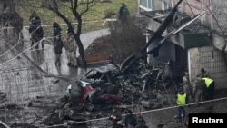 Petugas penyelamat berada di lokasi jatuhnya helikopter di Brovary, pinggiran ibu kota Kyiv, Ukraina, Rabu (18/1).