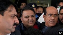 Petugas polisi berpakaian preman mengawal Fawad Chaudhry (tengah), pemimpin senior partai mantan Perdana Menteri Imran Khan, setelah pemeriksaan medial di sebuah rumah sakit di Lahore, Pakistan, 25 Januari 2023.