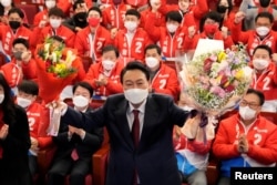 윤석열(가운데) 한국 대통령 당선인이 지난 10일 선거 승리 확정 직후 당사에서 축하받고 있다.