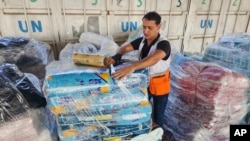 FILE - A United Nations worker prepares aid for distribution to Palestinians at a UNRWA warehouse in Deir Al-Balah, Gaza Strip, on Oct. 23, 2023.