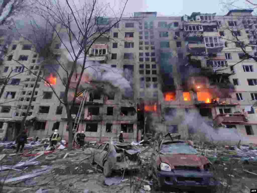 In this handout picture taken and released by the State Emergency Service of Ukraine on March 14, 2022, firefighters extinguish a fire in an apartment building hit by shelling in the Obolon district of Kyiv.