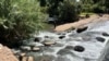 Zimbabweans use river water for chores despite raw sewage flowing in Harare. (Columbus Mavhunga/VOA)