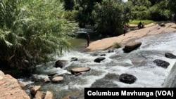 Zimbabweans use river water for chores despite raw sewage flowing in Harare. (Columbus Mavhunga/VOA)