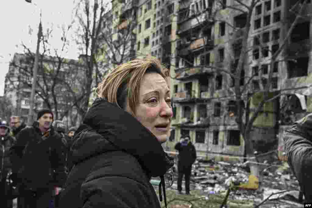 A woman reacts as she stands outside destroyed apartment blocks following shelling in the northwestern Obolon district of Kyiv, March 14, 2022. Two people were killed as various neighborhoods of the Ukraine capital Kyiv came under shelling and missile attacks, city officials said, after the Russia's military invaded the Ukraine on Feb. 24, 2022.