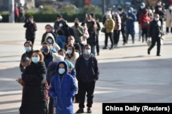 Residents line up outside a pharmacy to buy antigen testing kits for the coronavirus disease (COVID-19), in Nanjing, Jiangsu province, China, Dec. 15, 2022.