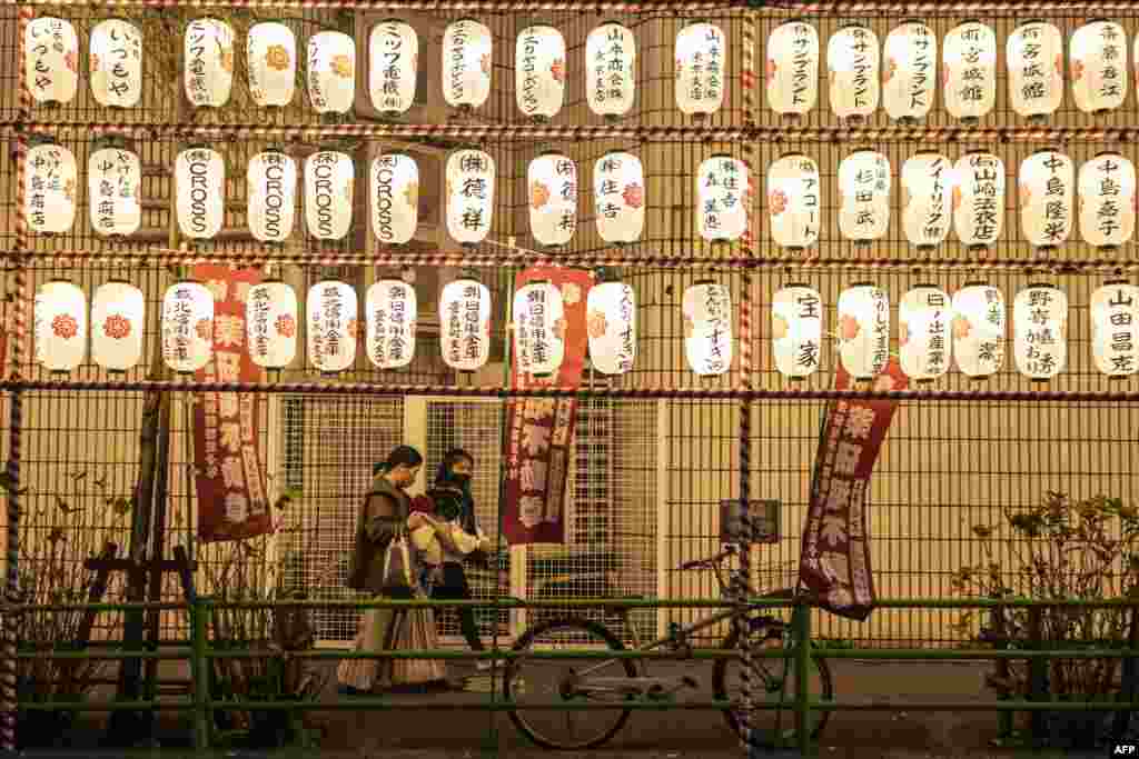 People walk past paper lanterns at a year-end fair in the Nihonbashi district of Tokyo, Japan.