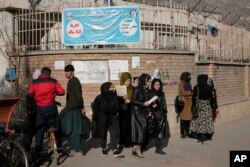 Mahasiswa perempuan Afghanistan berdiri di luar Universitas Kabul di Kabul, Afghanistan, pada 21 Desember 2022. (Foto oleh AP)