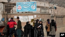 FILE - Afghan women students stand outside the Kabul University in Kabul, Afghanistan, Dec. 21, 2022. The United Nations' human rights chief on Dec. 27, 2022, decried increasing restrictions on women's rights in Afghanistan.