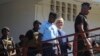 FILE - Former Comorian President Ahmed Abdallah Sambi, escorted by Gendarmes, arrives at the courthouse in Moroni, Nov. 21, 2022. Sambi, who served as president from 2006-2011, has been held under house arrest since May 2018.