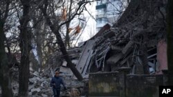 Seorang pria tampak berjalan melewati reruntuhan bangunan sekolah yang hancur diterjang oleh pasukan Rusia di Kramatorsk, wilayah Donetsk, Ukraina, pada 22 Desember 2022. (Foto: AP/Libkos)