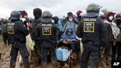A demonstrator in a wheelchair takes part in a protest near the opencast lignite mine Garzweiler, in the village Luetzerath near Erkelenz, Germany, Jan. 14, 2023.