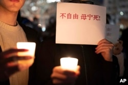 在美國首都華盛頓白宮附近舉行抗議的人群手舉反對中國政府嚴厲防疫政策的標語。 （2022年12月4日）