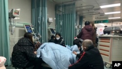 中國河北廊坊第四人民醫院急診室內病人家屬聚在病人床前。（2022年12月22日）
