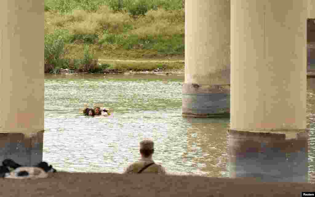Migrants swim across the Rio Grande in Eagle Pass, Texas, Dec. 18, 2022, as U.S. border cities brace for an influx of asylum seekers when COVID-era Title 42 migration restrictions are set to end.