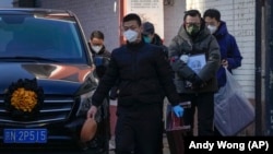 19일 중국 베이징의 고열 전문 병원에서 사망한 환자의 가족들이 시신을 운구하고 있다.