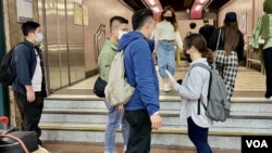 多名便衣警員在化名Anna 的中國內地留學生結束維園舉白紙示威後，跟蹤她到銅鑼灣地鐵站出入口，要求Anna搭地鐵離開。（美國之音/湯惠芸）