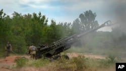 FILE - Ukrainian soldiers fire at Russian positions from a U.S.-supplied M777 howitzer in Ukraine's eastern Donetsk region, June 18, 2022. The U.S. has committed more than $60 billion — including more than $43 billion in military aid — to Ukraine since Russia invaded Ukraine.  