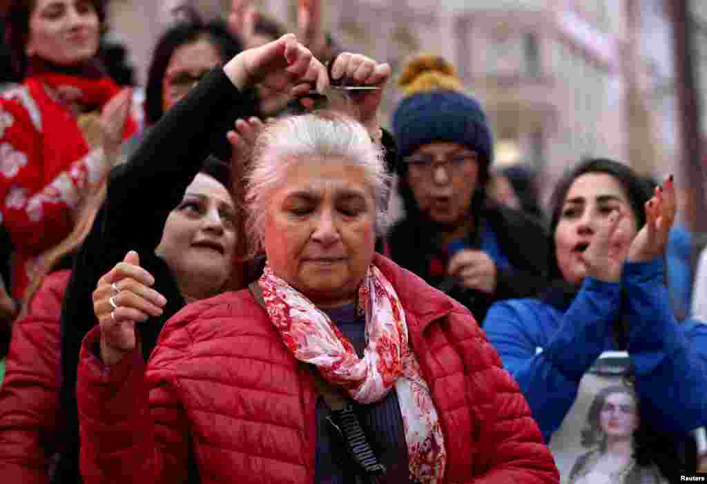 یک زن میانسال معترض در تظاهرات همبستگی در لندن اجازه می‌دهد تا گیسوانش را به نشانه همبستگی با زنان ایرانی ببرند، شنبه ۵ آذر 