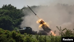 Ukrainian service members fire a BM-21 Grad multiple rocket launch system, near the town of Lysychansk, Luhansk region, amid Russia's attack on Ukraine, June 12, 2022. 
