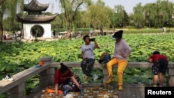 People and children enjoy themselves by the lakeside at a park during the Dragon Boat festival holiday, following the COVID-19 outbreak in Beijing, China, June 4, 2022.