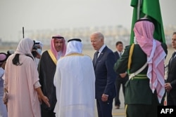 Presiden AS Joe Biden disambut oleh gubernur Mekah Pangeran Khaled al-Faisal (jubah putih) dan Putri Reema binti Bandar Al-Saud (kiri) di Bandara Internasional King Abdulaziz di kota pesisir Saudi, Jeddah, setibanya dari Israel, pada 15 Juli 2022. (Foto: AFP)