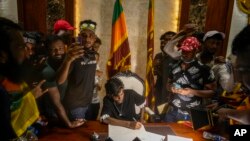 Pengunjuk rasa saat menyerbu kantor Perdana Menteri Sri Lanka Ranil Wickremesinghe, menuntut dia mengundurkan diri setelah Presiden Gotabaya Rajapaksa melarikan diri dari negara itu di tengah krisis ekonomi di Kolombo, Sri Lanka, Rabu, 13 Juli 2022. (Foto: AP )