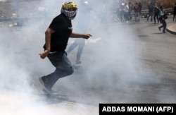 Pelajar Palestina lari dari gas air mata saat mereka bentrok dengan pasukan keamanan Israel di pintu masuk utara ke kota Ramallah, Tepi Barat, selama protes terhadap serangan Israel yang sedang berlangsung di Gaza, pada 6 Agustus 2022. (Foto: AFP)