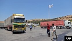 A convoy transporting humanitarian aid crosses into Syria from Turkey through the Bab al-Hawa border crossing on July 8, 2022. 