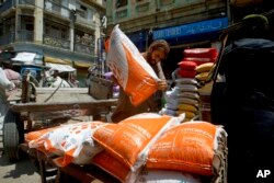 A laborer unload sacks of chickpeas at a market in Karachi, Pakistan, July 14, 2022. The International Monetary Fund said Thursday it had reached a preliminary agreement with Pakistan to revive a $6 billion bailout package.
