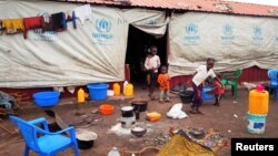 FILE - Children walk out of a tent at a refugee camp in Dundo, Angola, Sept. 12, 2017. Under a renewed repatriation initiative, dozens of Congolese left Angola for their home country Tuesday.