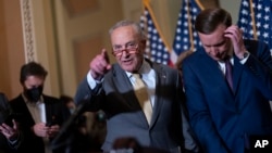 Senate Majority Leader Chuck Schumer, D-N.Y., joined at right by Sen. Chris Murphy, D-Conn., speaks with reporters following a closed-door policy lunch in Washington, June 14, 2022.