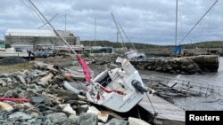 A sailboat lies washed up on shore following after the area was hit by Hurricane Fiona, in Shearwater, Nova Scotia, Canada, Sept. 24, 2022.