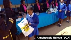 Amalunga eZim Mbokodo Women's Group besipha isipho semvunulo kumatnombazana aweMzinyathini High School