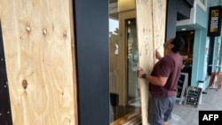 A man boards up a store in Hamilton, Bermuda, on Sept. 22, 2022